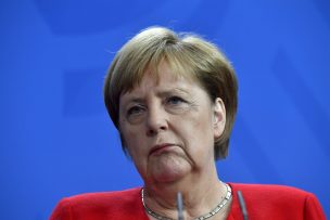 Merkel otra vez sentada durante los himnos nacionales en ceremonia oficial