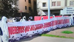 Personas con overoles blancos y mascarillas realizan manifestación en Plaza Baquedano