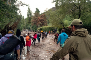 Funcionarios de Carabineros ayudan en la evacuación de personas damnificadas por los desprendimientos de tierra en San José de Maipo