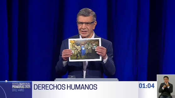 Debate de Primarias: Lavín muestra fotografía del funeral de Marchant y asegura que “a estas personas quiere indultar la CC”
