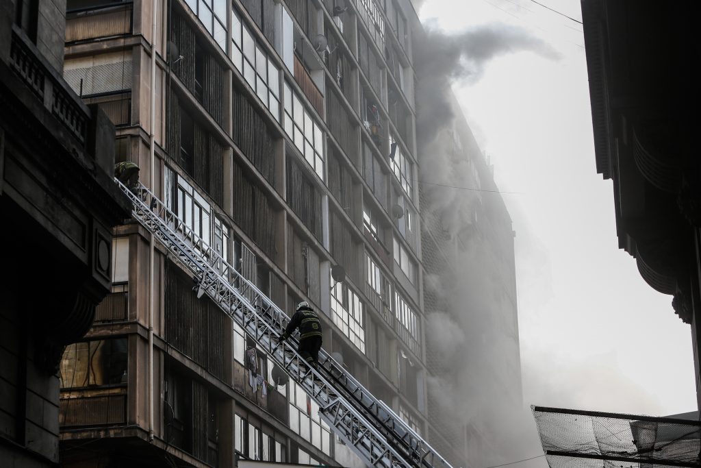 Incendio en edificio del centro de Santiago deja decenas de personas atrapadas: Bomberos lidera rescate de afectados