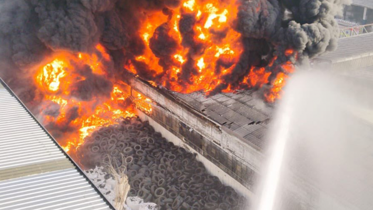 Advierten presencia de humo tóxico por enorme incendio en fábrica de neumáticos: Bomberos combate la emergencia